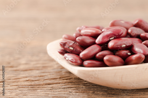 Red kidney bean close up rith spoon on wooden desk photo