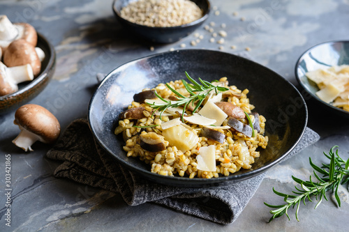 Vegetarian barley risotto with roasted mushrooms, fennel and Parmesan cheese slices photo