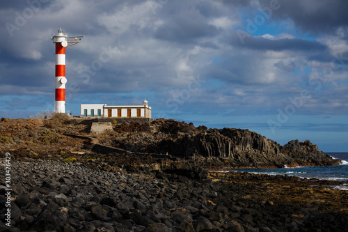 Punta Abona lighthouse. Landscape overlooking the ocean. Sunset. The water is shiny. Tenerife Island, Spain photo