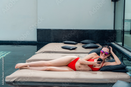 Fotografia, Obraz woman lying on a lounger by the pool at the hotel.