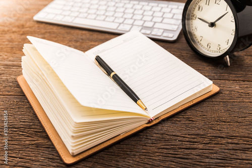 Open notebook on work space office table and computer keyboard