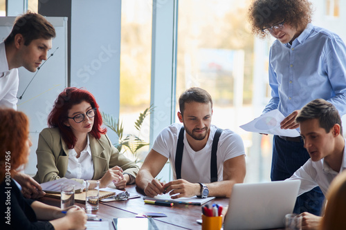creative and enthusiastic business group sitting in office together working as team, wearing formal wear. Caucasian business people