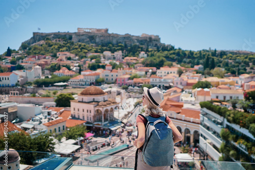 Enjoying vacation in Greece. Young traveling woman with rucksack enjoying view of Athens city and Acropolis.