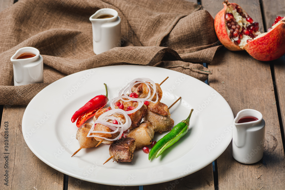 Grilling pork shashlik on barbecue grill with sauces tkemali and satsebeli Selective focus Grilling pork shashlik on barbecue grill with sauces tkemali and satsebeli Selective focus
