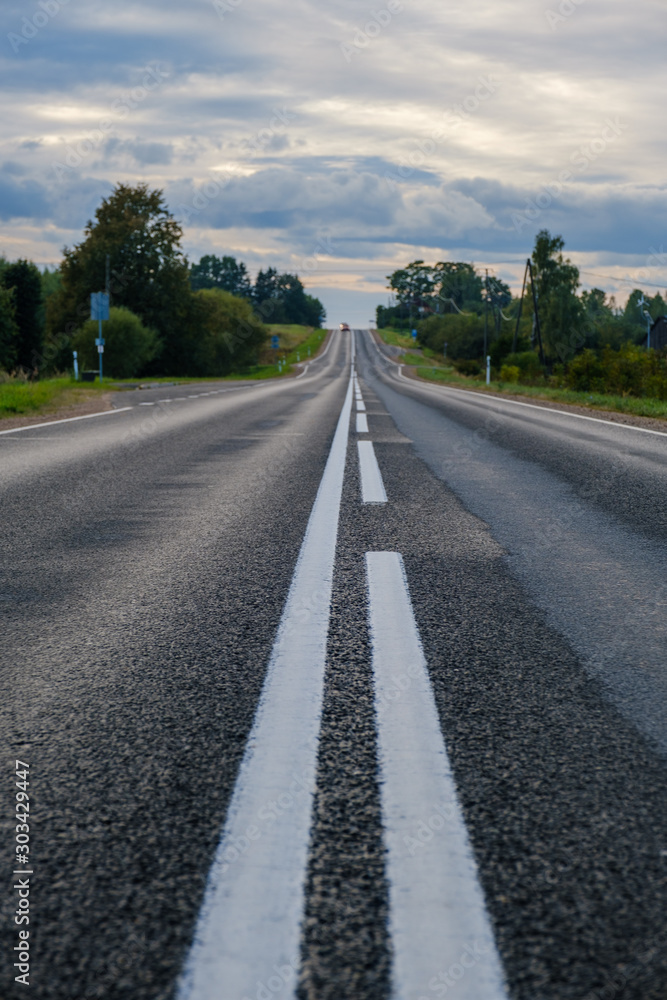 A magnificent view of the paved road leaving for horizon. Road in the forest through hill.