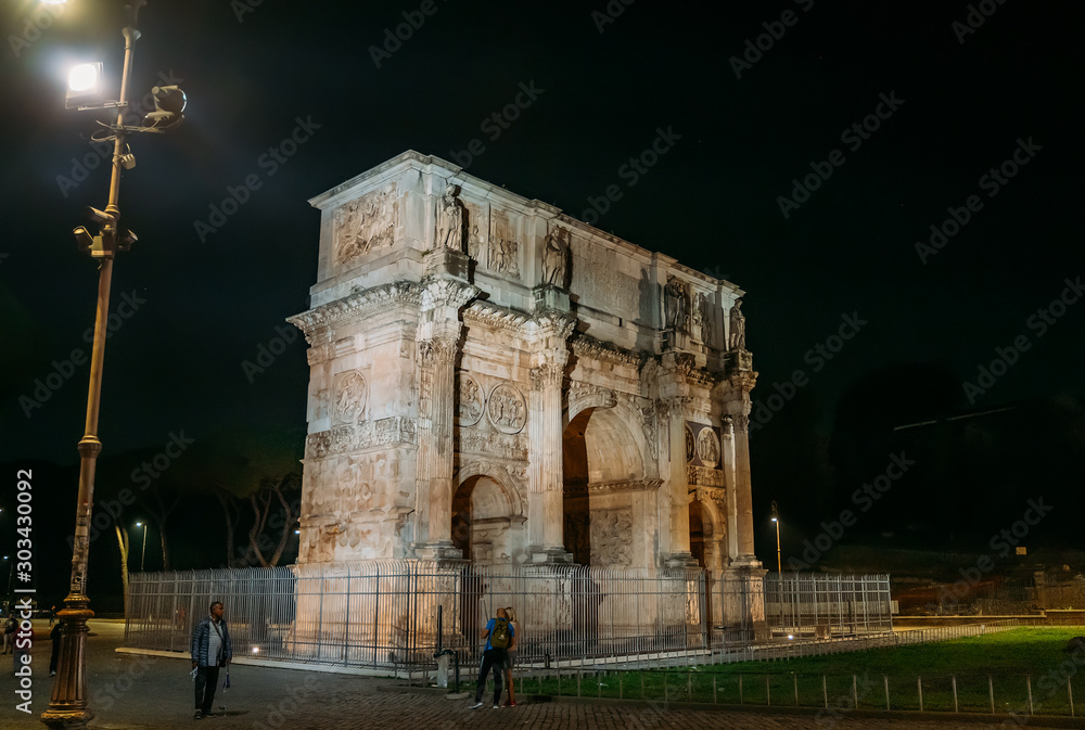 Rome, Italy - October 2019 : Arch of Constantine or Arco di Costantino or Triumphal arch in Rome at night, Italy near Coliseum.