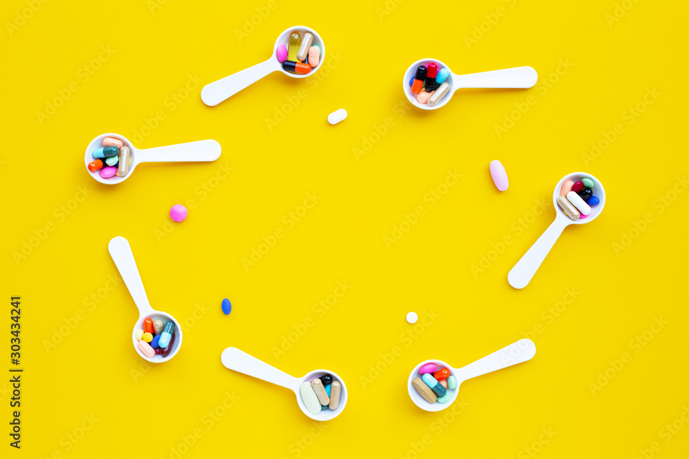 Colorful tablets with capsules and pills on yellow background. Colorful tablets with capsules and pills on yellow background.