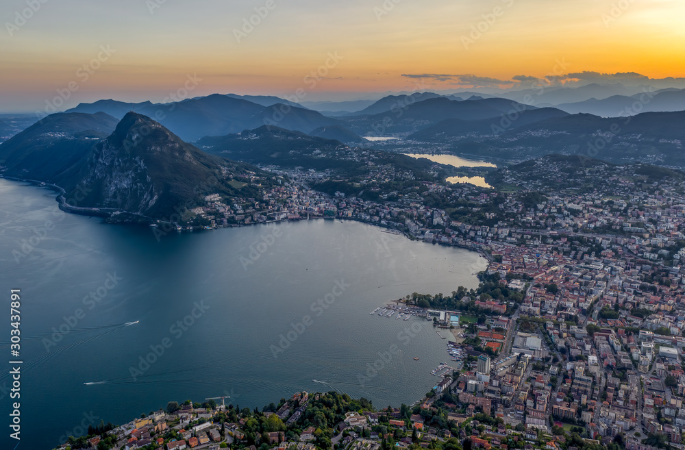 Aerial drone shot view before sunset of Swiss city Lugano and Monte Salvatore by Lago di lugano