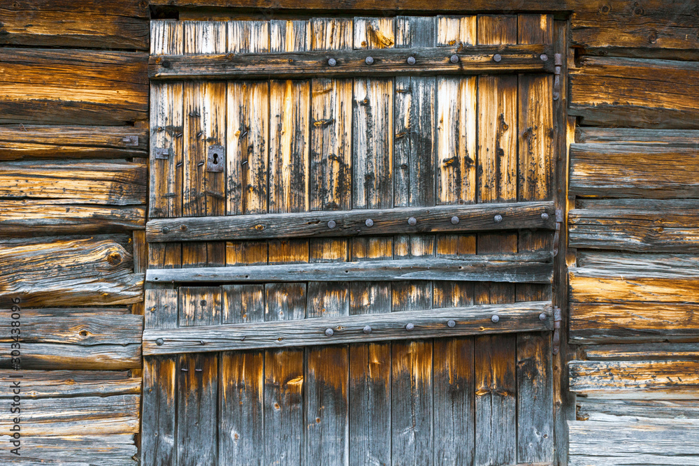 Old weathered and rustic door into abandoned building outdoors in the norwegian mountains. Texture and pattern concept.