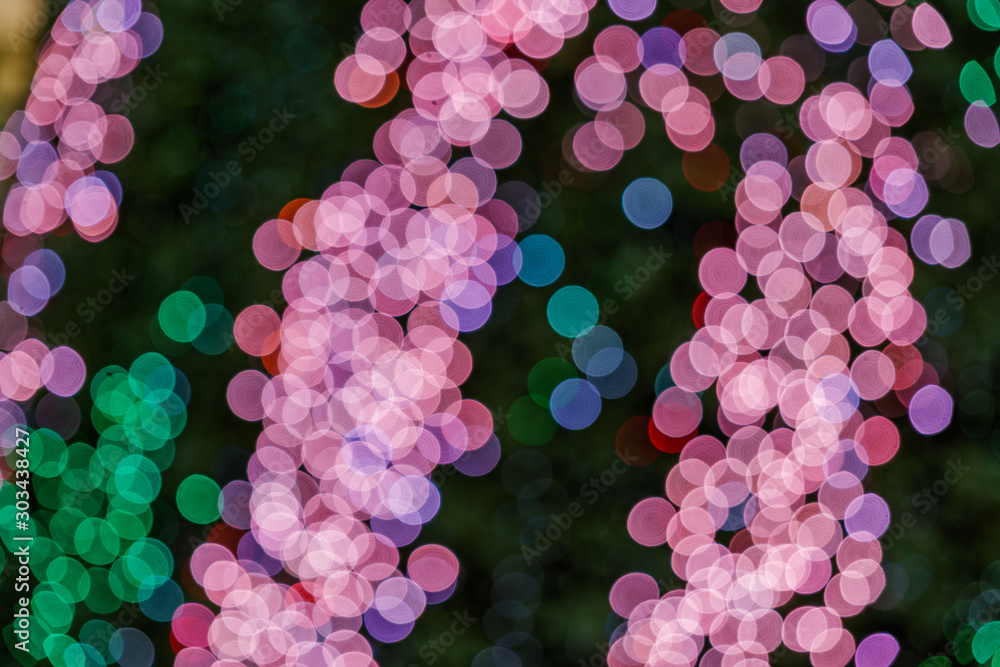Illuminated abstract round red, purple, blue, green and magenta bokeh on dark background. Colourful glitter bokeh from out of focus view of decoration bulbs. Illuminated abstract round red, purple, blue, green and magenta bokeh on dark background. Colourful glitter bokeh from out of focus view of decoration bulbs.