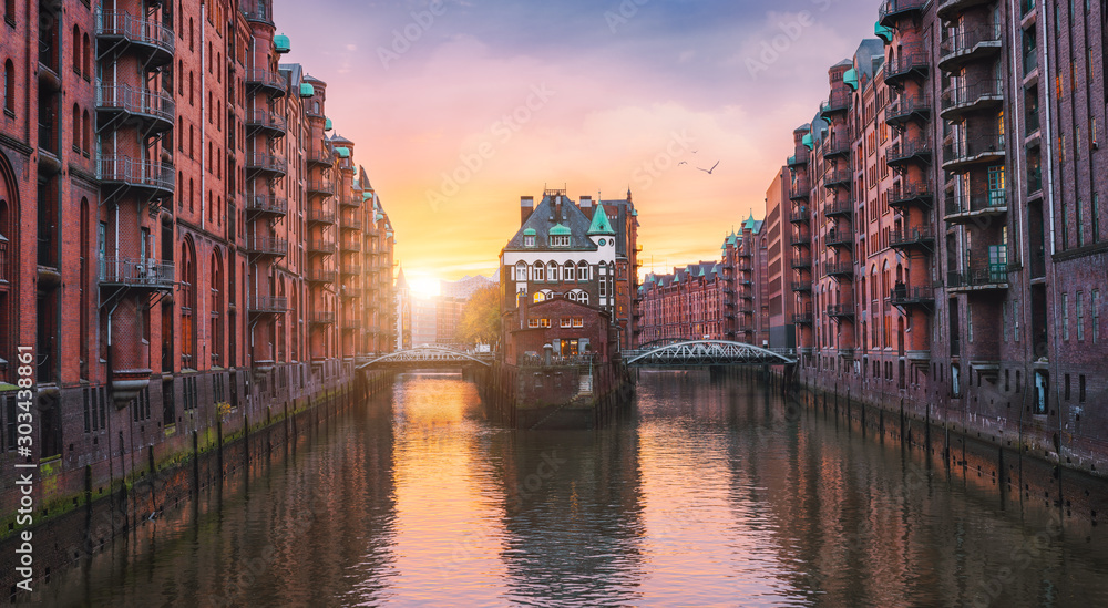 Hamburg city old port, Germany, Europe. Historical famous warehouse district with water castle palace at sunset golden light. Panoramic picture scene