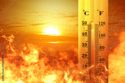 Thermometer with high temperature on the city with glowing sun background photo