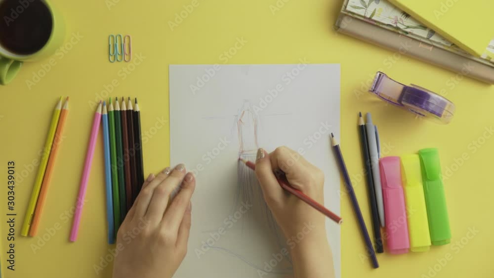 Top view of fashion designer use colour pencils to drawing dress sketch Top view of fashion designer use colour pencils to drawing dress sketch