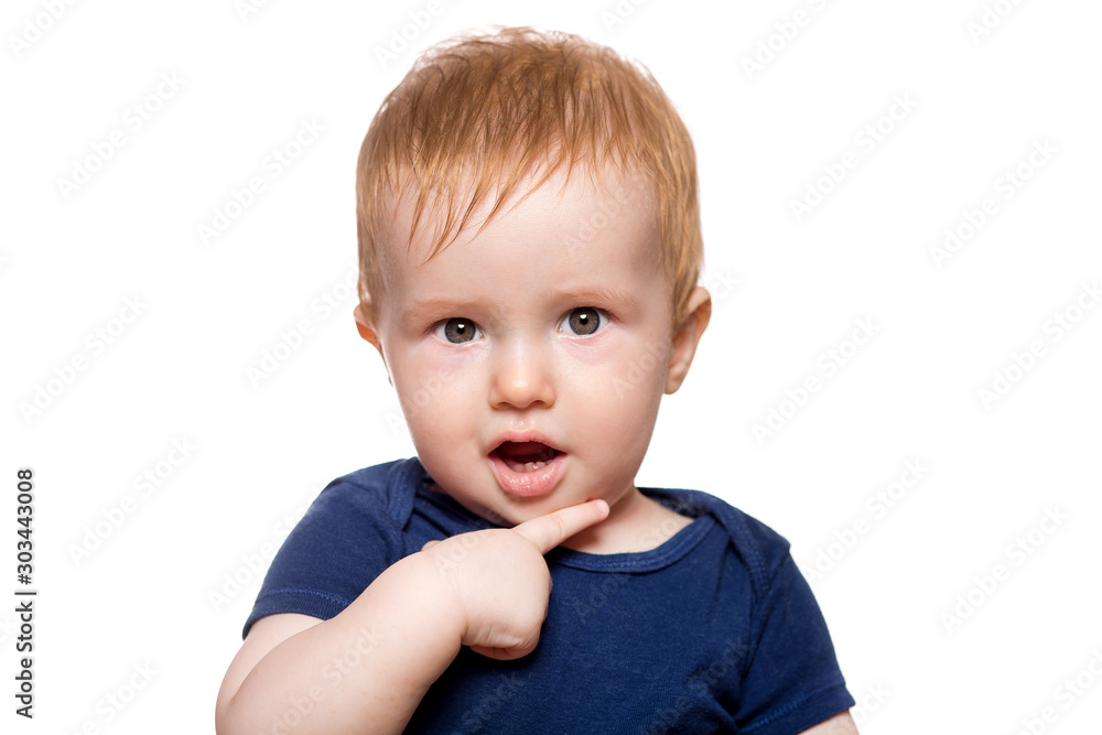 the boy enthusiastically looks into the camera holding his hand in the face with a surprised expression on his face, portrait of a toddler isolated on a white background. the boy enthusiastically looks into the camera holding his hand in the face with a surprised expression on his face, portrait of a toddler isolated on a white background.