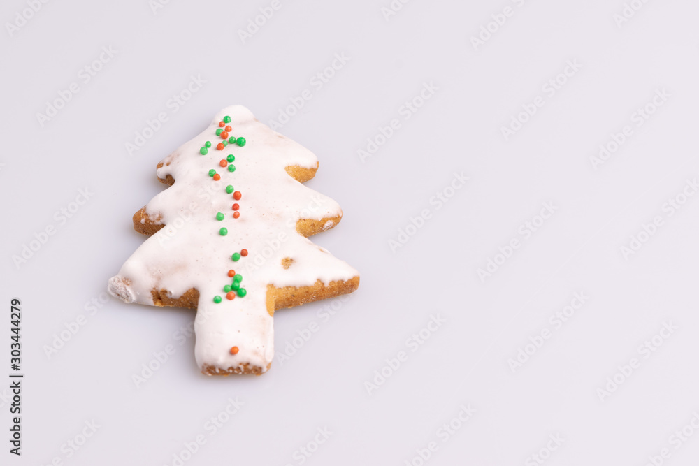 Christmas Ginger and Honey cookie. Gingerbread cookie in tree shape isolated on white background.