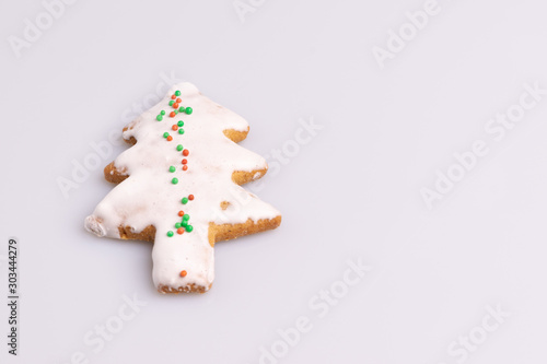 Christmas Ginger and Honey cookie. Gingerbread cookie in tree shape isolated on white background. © Romualdo