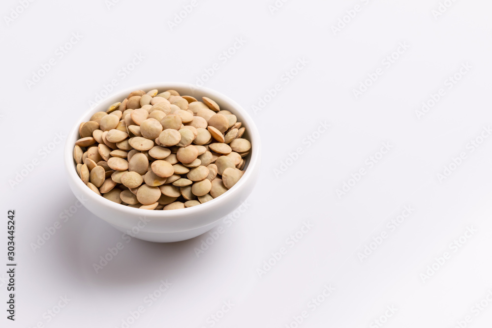 Dry uncooked lentils isolated on white background, copy space, studio shot, soft light. Christmas and New Year dish Dry uncooked lentils isolated on white background, copy space, studio shot, soft light. Christmas and New Year dish