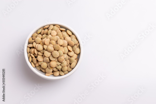 Dry uncooked lentils isolated on white background, copy space, studio shot, soft light. Christmas and New Year dish