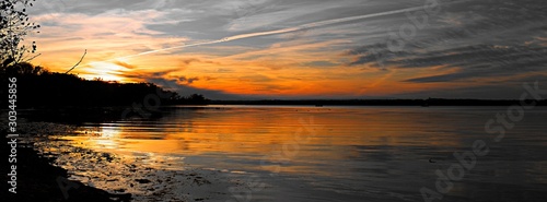 Vivid sunset over the Belmont Bay of water  with coast in silhouette