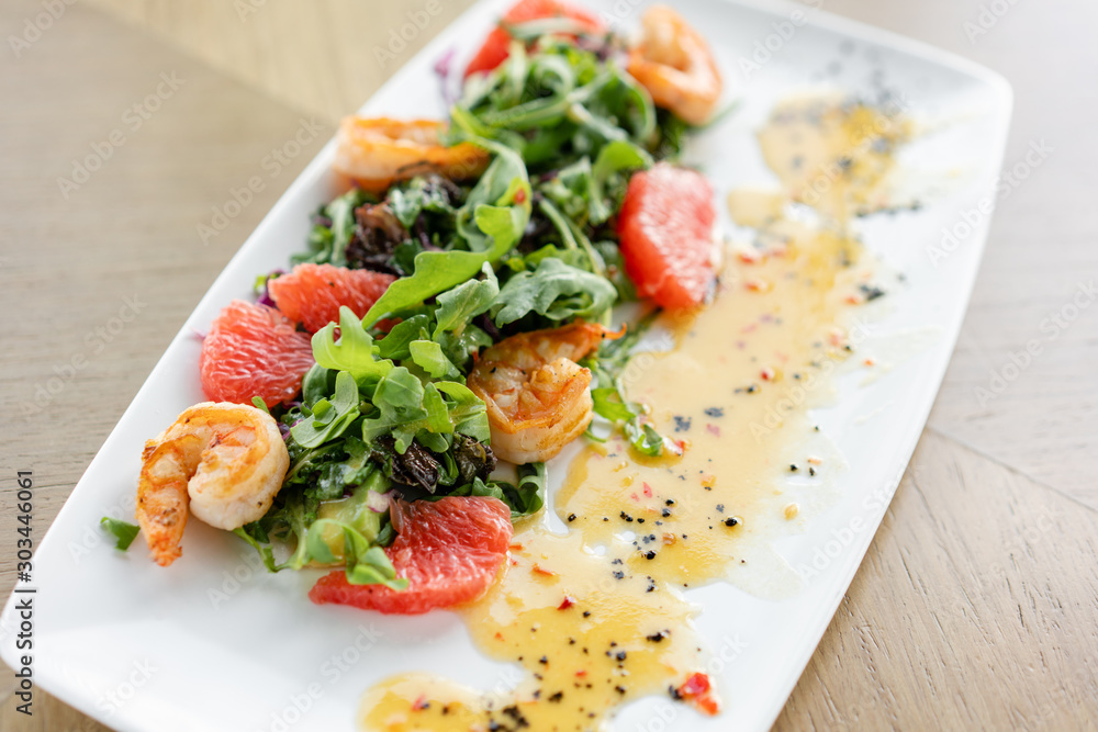 Delicious dish with grilled shrimps, slice grapefruit and arugula salad and spicy fried prawns. Restaurant menu, natural and organic food concept. Delicious dish with grilled shrimps, slice grapefruit and arugula salad and spicy fried prawns. Restaurant menu, natural and organic food concept.