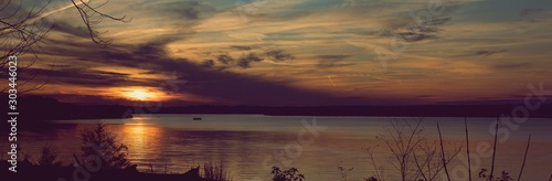 Vivid sunset over the Belmont Bay of water, with coast in silhouette