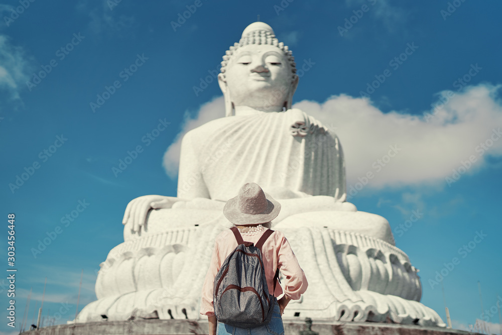 Fototapeta premium Traveling by Thailand. Pretty young woman walking in the Big Buddha Temple, famous Phuket sightseeing.