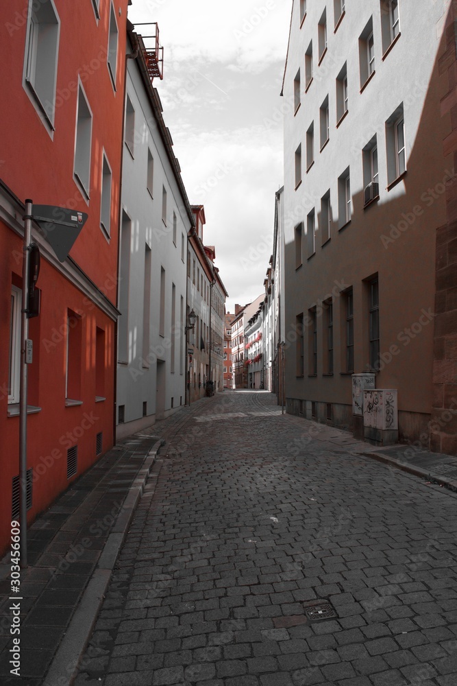 Fototapeta premium Looking down narrow road lined with houses