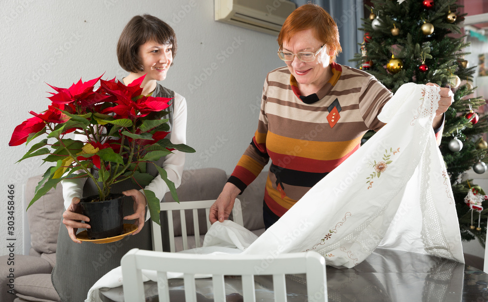 Φωτογραφία Mother and daughter with Poinsettia flowers in flowering pot at home