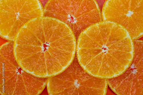 Fresh sliced juicy orange fruit set over orange background - tropical orange fruit texture for background use