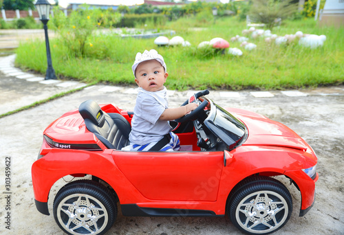 Asian baby boy siting on Toy car