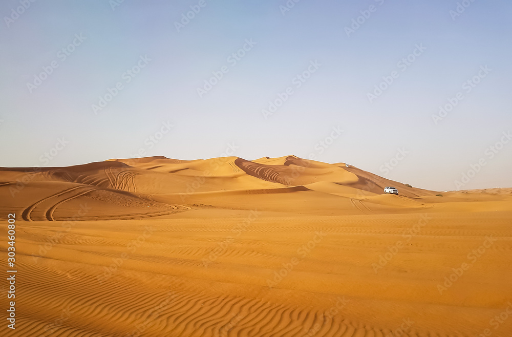 Landscape of desert in Dubai, sand dunes which lack of water and vegetation in hot weather under the blue sky in daylight, and rapid temperature change between day and night when darkness revisited.