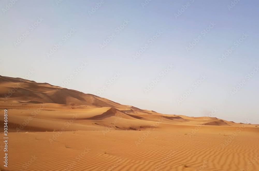 Landscape of desert in Dubai, sand dunes which lack of water and vegetation in hot weather under the blue sky in daylight and rapid temperature change between day and night when darkness revisited