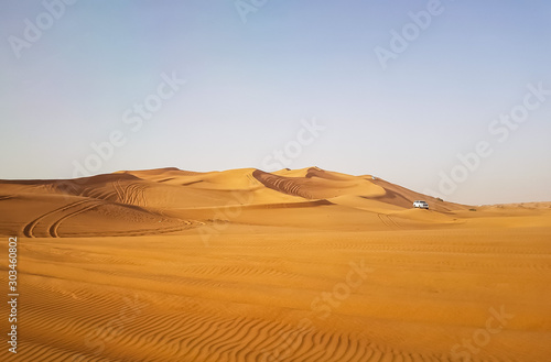 Landscape of desert in Dubai, sand dunes which lack of water and vegetation in hot weather under the blue sky in daylight, and rapid temperature change between day and night when darkness revisited.