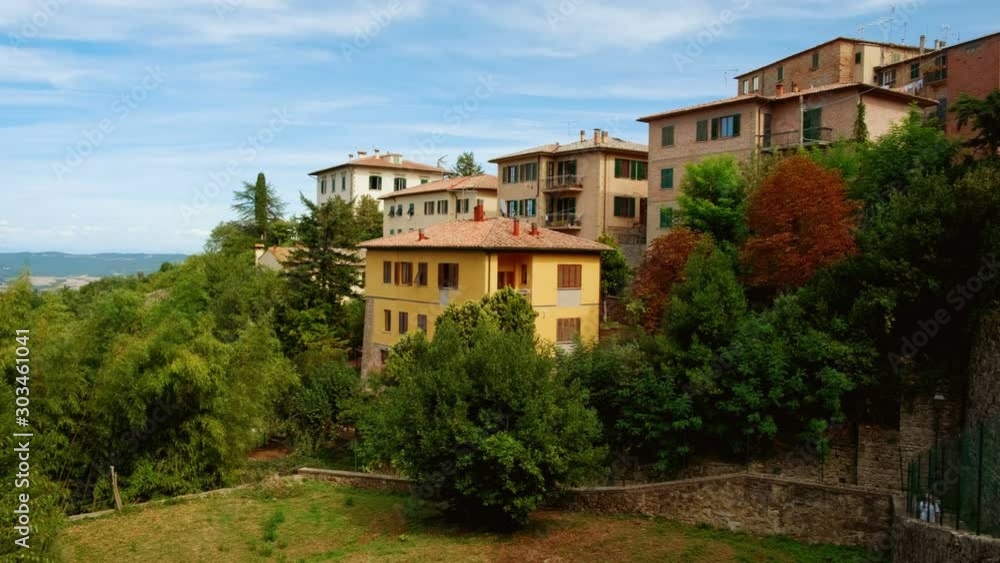 Close-up view of the medieval golden architecture of Volterra, a mountaintop town in Tuscany, Italy, contrasting with green scenery Close-up view of the medieval golden architecture of Volterra, a mountaintop town in Tuscany, Italy, contrasting with green scenery