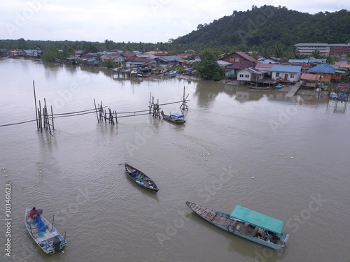 Kuching, Sarawak / Malaysia - November 18 2019:  The scenery of a traditional fishing village at Kuching, Sarawak, Malaysia. With the fishing boats along the Sarawak River and the villages on both sid photo