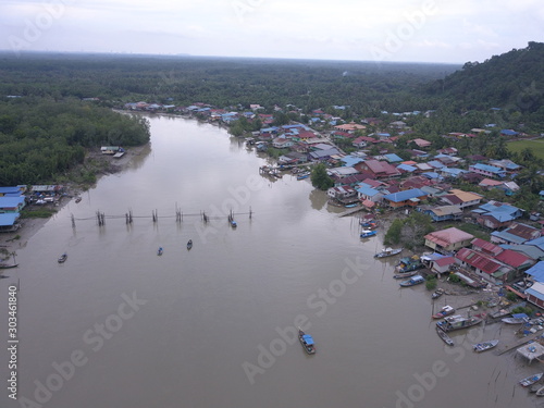 Kuching, Sarawak / Malaysia - November 18 2019:  The scenery of a traditional fishing village at Kuching, Sarawak, Malaysia. With the fishing boats along the Sarawak River and the villages on both sid photo