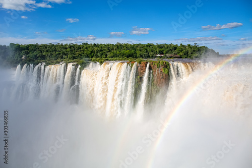 View to Devil s Throat and Salto Union with rainforest  blue sky  white clouds and small rainbow  Iguazu Falls  Argentina