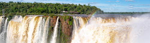 Panorama of Devil`s Throat and Salto union with blue sky, white clouds and small rainbow, Iguazu Falls, Argentina photo