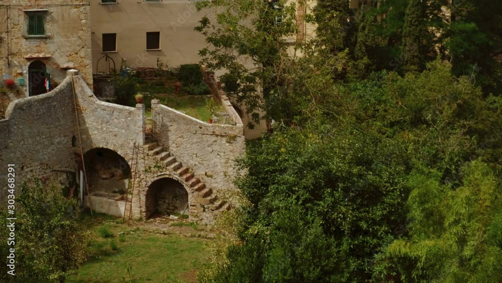 Close-up view of the medieval golden architecture of Volterra, a mountaintop town in Tuscany, Italy, contrasting with green scenery Close-up view of the medieval golden architecture of Volterra, a mountaintop town in Tuscany, Italy, contrasting with green scenery