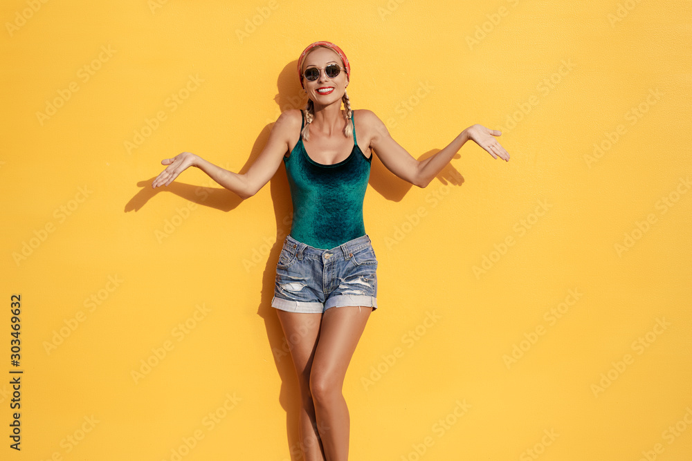 Don't know! Confused young woman against yellow wall. Don't know! Confused young woman against yellow wall.