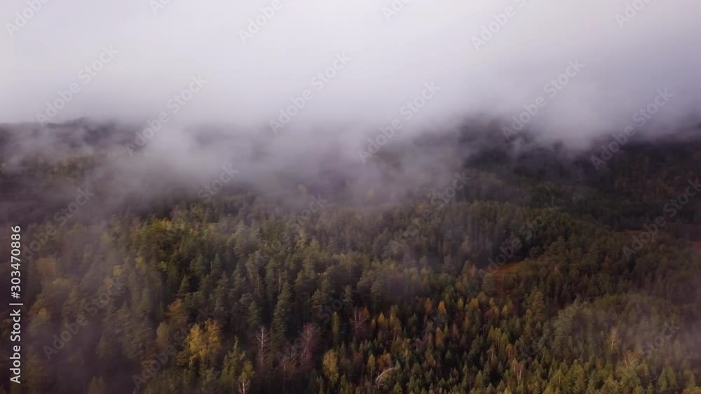Aerial, pan, drone shot, overlooking fog, above hills and foliage forest, on a foggy, autumn day, in Flakk, Aust-Agder, South Norway Aerial, pan, drone shot, overlooking fog, above hills and foliage forest, on a foggy, autumn day, in Flakk, Aust-Agder, South Norway