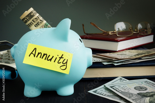 Annuity written on yellow sheet and piggy bank with money. photo