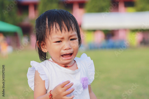 Soft focus.​ Portrait image of 1 years and 4 months old baby girl. Asian child girl crying when she playing with the toy at the playground. Expression and emotions of baby concept.