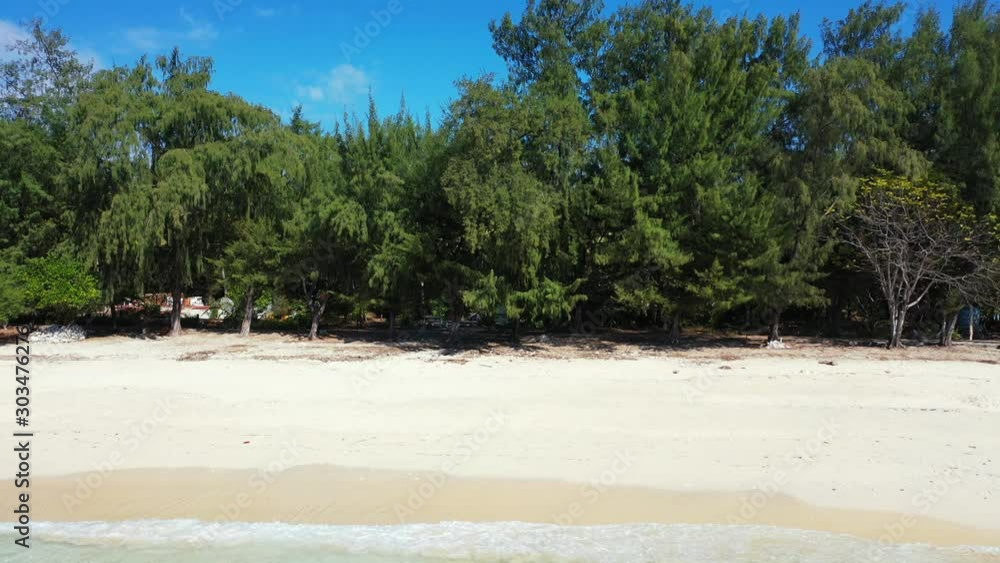 Lush vegetation of tropical island shade over white clean beach washed by waves of calm lagoon in Dominican Republic Lush vegetation of tropical island shade over white clean beach washed by waves of calm lagoon in Dominican Republic