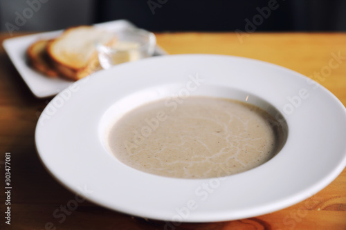 Apptetizer mushroom soup with bread on wood background