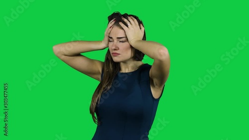Girl having a headache in front of a green screen photo