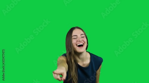 Girl making fun out of something in front of a green screen photo
