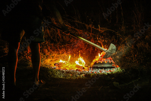 Cooking of peka, podpeka on open fire grill at night. Traditional food in croatia or balkans using sac or sache photo