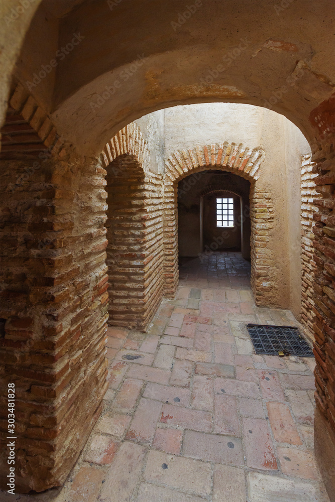 Obraz premium Red brick rooms with round arches in the walls of the old Alcazaba. Malaga, Andalusia, Spain