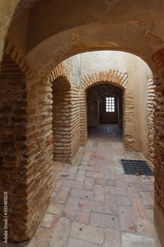 Red brick rooms with round arches in the walls of the old Alcazaba. Malaga, Andalusia, Spain